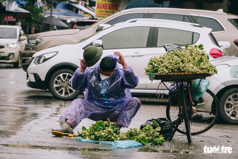 Người lao động ở Hà Nội trùm áo mưa, đốt lửa chống rét để mưu sinh - Ảnh 1. Người lao động ở Hà Nội trùm áo mưa, đốt lửa chống rét để mưu sinh - Ảnh 1.