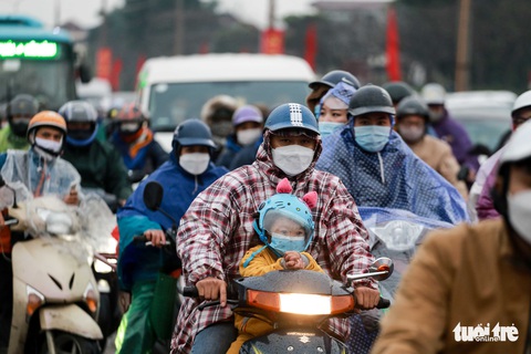 Người dân đội mưa, rét trở lại thủ đô chiều mùng 5 Tết - Ảnh 1. Người dân đội mưa, rét trở lại thủ đô chiều mùng 5 Tết - Ảnh 1.