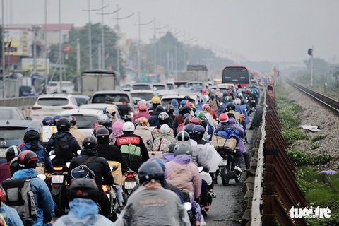 Người dân đội mưa trở lại Hà Nội mùng 6 Tết, cửa ngõ phía Nam ùn ứ kéo dài - Ảnh 7. Người dân đội mưa trở lại Hà Nội mùng 6 Tết, cửa ngõ phía Nam ùn ứ kéo dài - Ảnh 7.