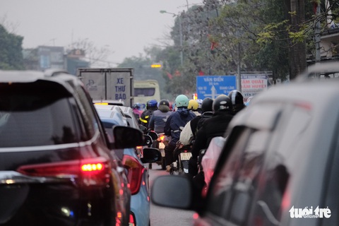 Người dân đội mưa trở lại Hà Nội mùng 6 Tết, cửa ngõ phía Nam ùn ứ kéo dài - Ảnh 12. Người dân đội mưa trở lại Hà Nội mùng 6 Tết, cửa ngõ phía Nam ùn ứ kéo dài - Ảnh 12.