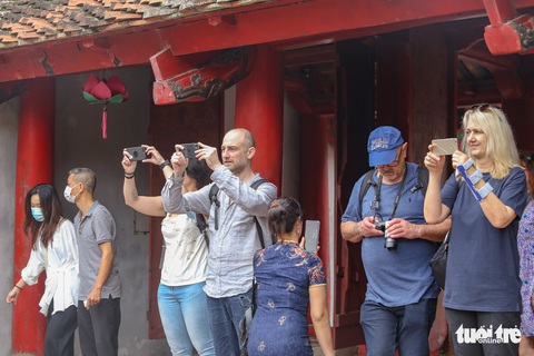 Du khách nước ngoài thích thú chụp ảnh tốt nghiệp cùng học sinh Việt Nam - Ảnh 3. Du khách nước ngoài thích thú chụp ảnh tốt nghiệp cùng học sinh Việt Nam - Ảnh 3.