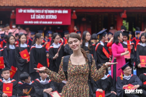 Du khách nước ngoài thích thú chụp ảnh tốt nghiệp cùng học sinh Việt Nam - Ảnh 2. Du khách nước ngoài thích thú chụp ảnh tốt nghiệp cùng học sinh Việt Nam - Ảnh 2.