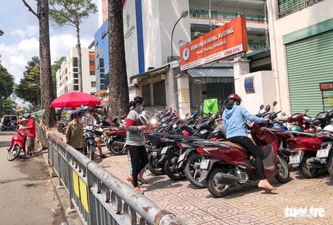 TP.HCM còn nhiều bãi xe chiếm vỉa hè trước bệnh viện - Ảnh 2. TP.HCM còn nhiều bãi xe chiếm vỉa hè trước bệnh viện - Ảnh 2.
