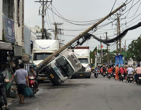 Trụ điện ngã đè trúng xe tải, nghi bị xe container quẹt cuốn bó cáp viễn thông - Ảnh 1. Trụ điện ngã đè trúng xe tải, nghi bị xe container quẹt cuốn bó cáp viễn thông - Ảnh 1.
