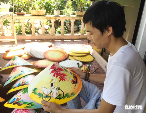 Chàng trai vẽ tranh trên nón lá Huế - Ảnh 1. Chàng trai vẽ tranh trên nón lá Huế - Ảnh 1.