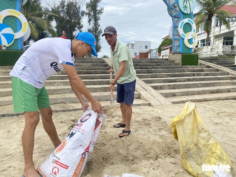 Dân ven biển Quảng Nam xúc cát, cột dây thừng chằng chống nhà cửa, hàng quán tránh bão - Ảnh 1. Dân ven biển Quảng Nam xúc cát, cột dây thừng chằng chống nhà cửa, hàng quán tránh bão - Ảnh 1.
