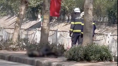 Người phụ nữ dùng xăng tự thiêu trên phố Hà Nội - Ảnh 1. Người phụ nữ dùng xăng tự thiêu trên phố Hà Nội - Ảnh 1.