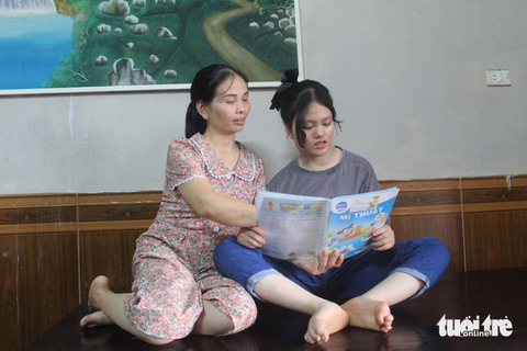 Cô gái bại não mang giấc mơ 'blouse trắng' - Ảnh 1. Với Liên, mẹ không chỉ có công sinh thành mà còn là cô giáo dạy cho Liên những nét chữ đầu đời - Ảnh: LƯƠNG HUYỀN