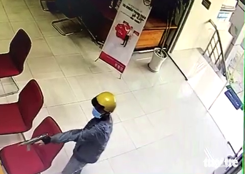 Khởi tố thanh niên dùng súng cướp ngân hàng tại Tiền Giang - Ảnh 3. Camera ghi lại cảnh nam thanh niên cướp ngân hàng - Ảnh: HOÀI THƯƠNG cắt từ clip