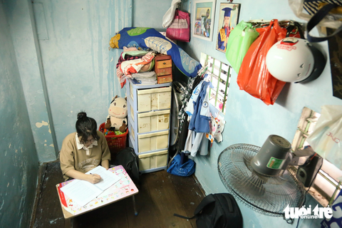 Học trong căn nhà 4m², nóng không thể cột mùng - Ảnh 3. Mỗi tối, Nguyên mở cái bàn xếp, cao một gang tay, bề ngang bốn tấc, bề dài sáu tấc, rồi cô gái ngồi xuống, lưng dựa vào vách nhà, hai chân đặt dưới bàn, học bài, làm bài nhiều khi đến nửa đêm - Ảnh: PHƯƠNG QUYÊN