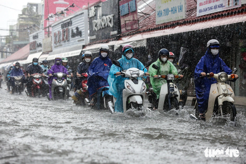 Mới mưa 30 phút đường đã ngập mênh mông, cá bơi lên đường - Ảnh 1. Người dân chật vật di chuyển trên đường Kha Vạn Cân (TP Thủ Đức) trong cơn mưa trưa 10-10