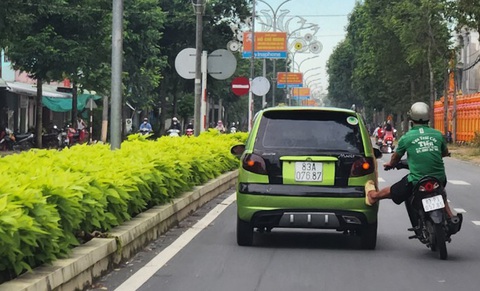 Truy tìm tài xế xe gắn máy 'cứu hộ xe hơi' - Ảnh 1. Hình ảnh xe gắn máy cứu hộ xe hơi, tiềm ẩn nguy cơ gây tai nạn giao thông - Ảnh: D.T.