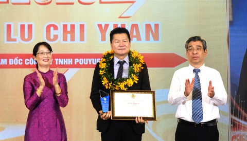 Thu nhập công nhân nhà máy chip trên 23 triệu đồng - Ảnh 1. Phó bí thư Thành ủy TP.HCM Nguyễn Phước Lộc (bìa phải) và Chủ tịch Liên đoàn Lao động TP.HCM Trần Thị Diệu Thúy trao bằng khen cho ông Lu Chi Yuan - giám đốc Công ty TNHH PouYuen Việt Nam - Ảnh: VŨ THỦY