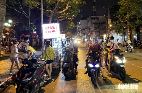 Hàng rong ‘bao vây’ công viên Tầm Vu, quận Bình Thạnh - Ảnh 8. Xe máy dàn hàng hai, hàng ba để mua hàng ở những xe hàng rong gây nguy hiểm cho những người khác đang đi trên đường - Ảnh: CHÂU TUẤN