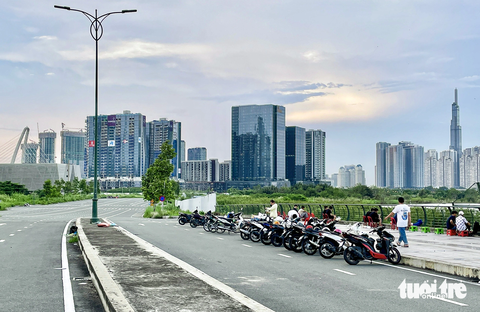 ‘Quái xế’ hoành hành khu đô thị Thủ Thiêm - Ảnh 9. Tại đoạn đường Trần Bạch Đằng (khu gần nóc hầm Thủ Thiêm) mặc dù có rào chắn và biển cấm tất cả xe cộ đi lại theo cả hai chiều nhưng vẫn có khá nhiều người đến - Ảnh: CHÂU TUẤN