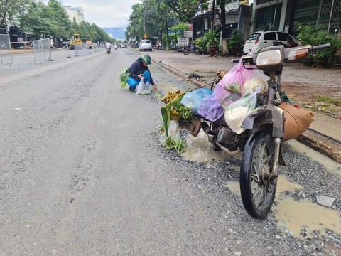 Mùa mưa lại đào đường thi công, dân khổ trăm bề - Ảnh 3. Tiểu thương bị đổ hàng vì tránh ô tô trên tuyến đường Lê Thánh Tôn - Ảnh: TRẦN MAI