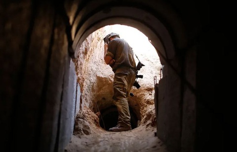Hamas và mạng lưới đường hầm dày đặc để đối đầu Israel - Ảnh 1. Binh sĩ Israel nhìn vào một đường hầm do quân đội Israel phát hiện gần khu định cư Ein Hashlosha, ngay bên ngoài Dải Gaza - Ảnh: REUTERS