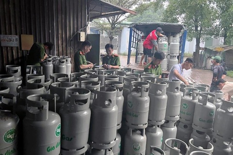 Khởi tố sáu người sản xuất, buôn bán gas giả - Ảnh 1. Lực lượng chức năng kiểm tra, bắt quả tang các nghi phạm sản xuất gas giả tại nhà kho công ty - Ảnh: Công an cung cấp