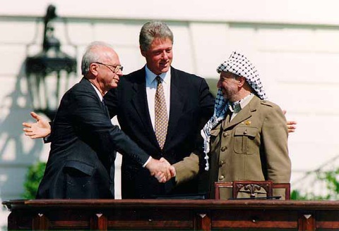 Cuộc intifada lần ba liệu sẽ bùng nổ? - Ảnh 2. Thủ tướng Israel Yitzhak Rabin (trái) bắt tay Chủ tịch Tổ chức giải phóng Palestine Yasir Arafat (phải) tại Lễ ký kết Hiệp định Oslo 1 ngày 13-9-1993 với sự chứng kiến của Tổng thống Mỹ Bill Clinton (giữa) - Ảnh: NHÀ TRẮNG