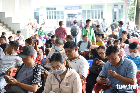 Dân TP.HCM đổ xô đi đổi bằng lái, các điểm tiếp nhận 'nghẹt thở' - Ảnh 2. Người dân ngồi chờ vật vã nhiều giờ đồng hồ đợi gọi tên - Ảnh: NGỌC QUÝ