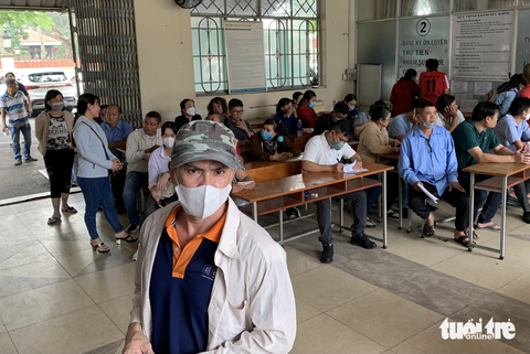 Dân TP.HCM đổ xô đi đổi bằng lái, các điểm tiếp nhận 'nghẹt thở' - Ảnh 4. Nhiều người chấp nhận ngồi đợi cho qua giờ nghỉ trưa để làm xong thủ tục cấp đổi bằng lái trong ngày - Ảnh: PHƯƠNG NHI