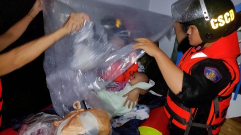 3h30 sáng, nhận tin nhiều người mặc kẹt trong ngập lụt, cảnh sát liền đến cứu - Ảnh 2. Các cán bộ, chiến sĩ cảnh sát cơ động hỗ trợ người dân vùng ngập lụt - Ảnh: H.B.
