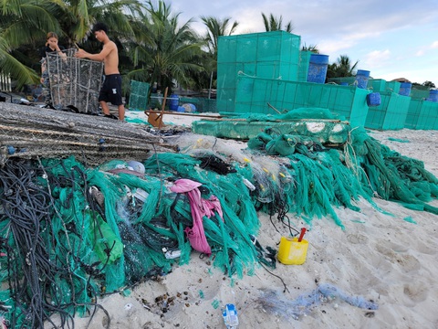 Biển Cam Ranh bị ô nhiễm vì rác thải từ lồng nuôi tôm hùm - Ảnh 1. Đủ loại rác thải như nhựa, lưới... chất thành đống tại bãi biển thuộc thôn Bình Lập - Ảnh: TRẦN HƯỚNG