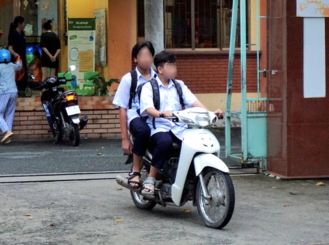 Học sinh cấp 2 vô tư đi xe máy - Ảnh 1. Học sinh cấp 2 chạy xe máy không kính chiếu hậu, không đội nón bảo hiểm - Ảnh: THÙY LINH