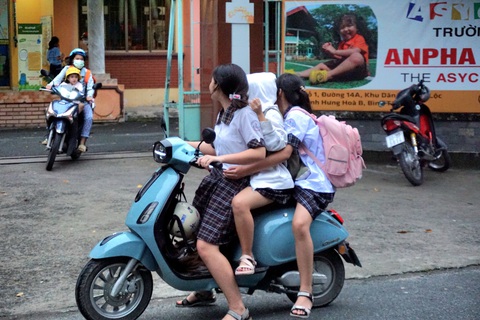 Học sinh cấp 2 vô tư đi xe máy - Ảnh 5. Học sinh tống ba trên xe máy điện. Theo quy định hiện nay, người đủ 16 tuổi mới được điều khiển xe máy điện - Ảnh: THÙY LINH