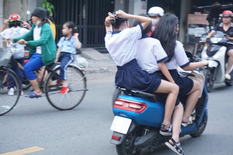 Học sinh cấp 2 vô tư đi xe máy - Ảnh 6. Nữ sinh tống ba trên xe máy điện - Ảnh: THÙY LINH