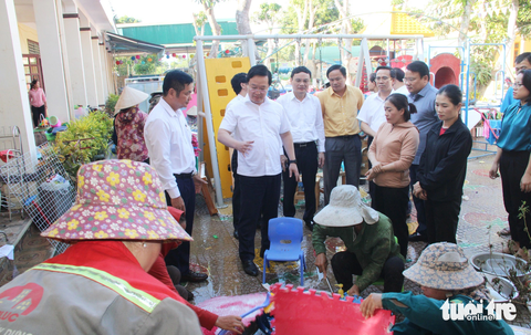 Nghệ An lập đoàn kiểm tra xả lũ của các thủy điện - Ảnh 1. Ông Nguyễn Đức Trung - phó bí thư Tỉnh ủy, chủ tịch UBND tỉnh Nghệ An - thăm hỏi, động viên các giáo viên ở Quỳ Châu khắc phục hậu quả mưa lũ - Ảnh: DOÃN HÒA