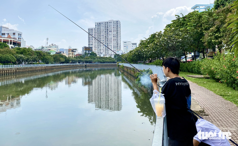 Những hình ảnh xấu xí dọc kênh Nhiêu Lộc - Thị Nghè - Ảnh 8. Dù đã đặt nhiều biển cấm nhưng người dân vẫn ngang nhiên đậu xe, câu cá - Ảnh: TIẾN QUỐC