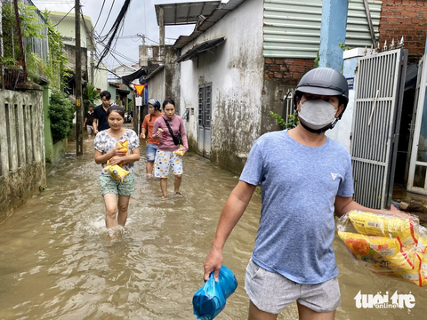 Ấm lòng bữa cơm nóng trong vùng 'rốn' ngập Đà Nẵng - Ảnh 2. Nhiều bà con vùng ngập trở về nhà với đồ ăn dự phòng được hỗ trợ từ các nhóm tình nguyện viên - Ảnh: TRƯỜNG TRUNG