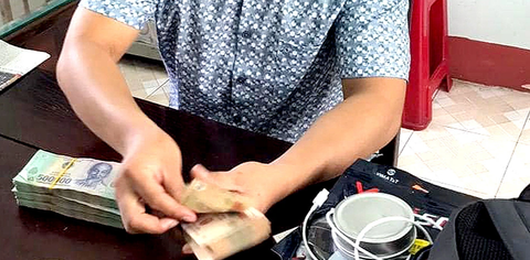 Ông D. đang kiểm tại số tiền trong túi xách bị bỏ quên tại bộ phận tiếp dân của Công an huyện Tuy An - Ảnh công an cung cấp Ông D. kiểm lại số tiền trong túi xách bị bỏ quên tại bộ phận tiếp dân của Công an huyện Tuy An - Ảnh công an cung cấp