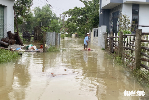 Ngập lũ nhiều nơi, dân dọn đồ đạc, hối hả dắt trâu 'chạy' lũ - Ảnh 10. Người dân cào bớt rác ra khỏi nhà - Ảnh: LÊ TRUNG