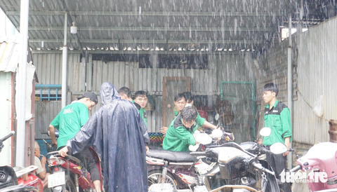 Bì bõm vào cắm chốt ‘rốn’ ngập lụt của Đà Nẵng để cứu chữa xe miễn phí giúp dân - Ảnh 1. Dưới cơn mưa tầm tã, sinh viên sửa xe cho người dân ở điểm ngập lụt nặng của Đà Nẵng - Ảnh: ĐOÀN CƯỜNG