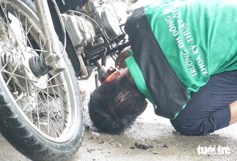 Bì bõm vào cắm chốt ‘rốn’ ngập lụt của Đà Nẵng để cứu chữa xe miễn phí giúp dân - Ảnh 2. Cần mẫn sửa xe cho bà con - Ảnh: ĐOÀN CƯỜNG