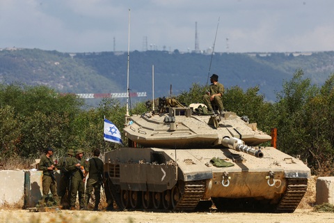 Hezbollah tuyên bố phá hủy mạng lưới camera giám sát biên giới của Israel - Ảnh 1. Binh sĩ Israel đứng cạnh xe tăng nằm gần biên giới Israel - Lebanon (phía bắc Israel) ngày 16-10 - Ảnh: REUTERS