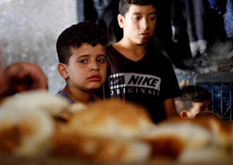 Một đứa trẻ Palestine nhìn bánh mì nướng trên lò củi trong bối cảnh thiếu nhiên liệu và điện tại Khan Younis ở phía nam Dải Gaza, ngày 16-10 - Ảnh: REUTERS Những đứa trẻ Palestine nhìn bánh mì nướng trên lò củi trong bối cảnh thiếu nhiên liệu và điện tại Khan Younis ở phía nam Dải Gaza, ngày 16-10 - Ảnh: REUTERS