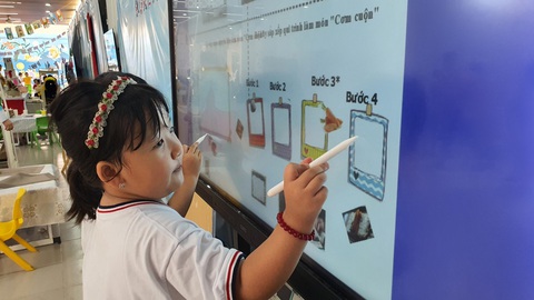 TP.HCM: Học sinh mầm non thích thú sắm vai nhân viên siêu thị - Ảnh 5. Trúc Quân, học sinh lớp lá, sử dụng bảng tương tác để sắp xếp các bước làm món cơm cuộn. Quân cho biết: "Trong lớp cô đã dạy con làm món cơm cuộn nhiều lần nên con thuộc hết các bước rồi"