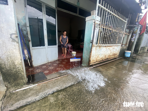 Vùng lũ Đà Nẵng tái ngập, quân đội và công an chốt chặn trước khu dân cư - Ảnh 4. Người phụ nữ này đã về nhà dọn lũ chiều 16-10 vì nghĩ nước không lên lại