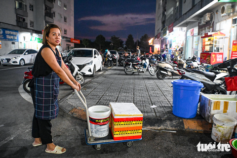 Cư dân chung cư Hà Nội quay cuống trong cơn khủng hoảng nước sạch - Ảnh 13. Bị cắt nước không chỉ ảnh hưởng tới sinh hoạt của cư dân mà những hộ kinh doanh cũng chịu thiệt hại nặng nề. Họ phải đi chở từng xô nước về cửa hàng - Ảnh: HỒNG QUANG