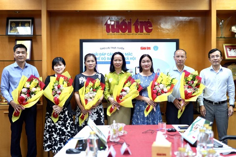 Đang giao lưu trực tuyến: Giải đáp thắc mắc về chế độ bảo hiểm xã hội - Ảnh 1. Phó tổng biên tập báo Tuổi Trẻ Trần Xuân Toàn (bìa phải) tặng hoa cho các khách mời tham dự chương trình - Ảnh: HỮU HẠNH
