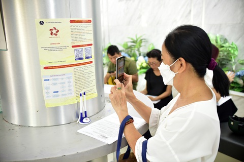 Cạnh tranh dịch vụ hành chính được không? - Ảnh 3. Người dân làm theo hướng dẫn cài đặt dịch vụ công quốc gia qua app tại UBND quận 1, TP.HCM - Ảnh: T.T.D.