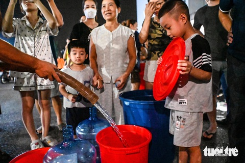 Dân khốn khổ vì cúp nước, Bí thư Hà Nội chỉ đạo phải cấp lại nước nhanh nhất cho dân - Ảnh 1. Cư dân khu đô thị Thanh Hà xếp hàng lấy nước trong đêm 17-10 - Ảnh: HỒNG QUANG