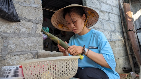 Nghị lực của nhừng cánh cò mồ côi xứ Huế - Ảnh 1. Cô sinh viên mồ côi Nguyễn Nữ Kiều Oanh (ngành ngôn ngữ Anh, Trường đại học Duy Tân, Đà Nẵng) cắt măng tre về nấu cho các em ăn - Ảnh: NHẬT LINH