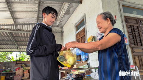 Vượt qua bệnh tật, sinh viên nghèo Huỳnh Văn Sinh đến giảng đường - Ảnh 7. Hay tin Sinh trúng tuyển vào đại học, hàng xóm láng giềng ai cũng mừng. Bà Huỳnh Thị Thơ (hàng xóm của Sinh) gói ghém gửi cho cậu tân sinh viên nghèo quả trứng gà, chai xì dầu đem lên phố - Ảnh: NHẬT LINH