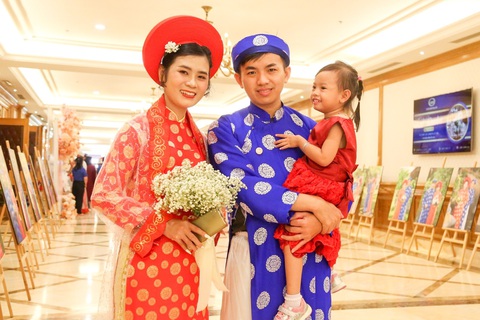 Lễ cưới tập thể của 82 cặp đôi trong ngày Phụ nữ Việt Nam - Ảnh 6. Cưới nhau đã lâu nhưng không có điều kiện tổ chức hôn lễ, vợ chồng Hạ Thị Duyên - Huỳnh Văn Toàn cùng con gái hào hứng tham dự lễ cưới đặc biệt của gia đình