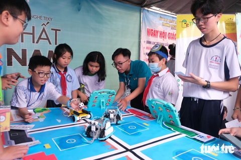 Gần 1.000 học sinh thích thú trải nghiệm Ngày hội Giáo dục STEM - Ảnh 7. Các em học sinh trải nghiệm điều khiển robot tại ngày hội - Ảnh: NGỌC PHƯỢNG