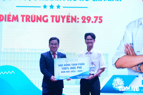Trao học bổng toàn phần cho thủ khoa đạt 29.75 điểm - Ảnh 1. PGS.TS Ngô Quốc Đạt - phó hiệu trưởng Trường đại học Y Dược TP.HCM - trao học bổng toàn phần cho thủ khoa Nguyễn Duy Hậu - Ảnh: NGỌC PHƯỢNG